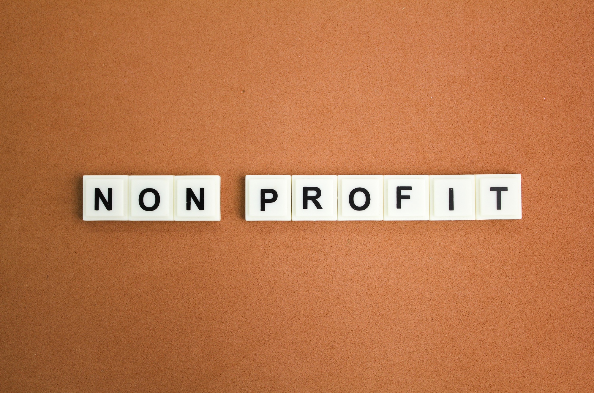 calculator, magnifying glass, paper money, pen and stick with the word nonprofit.